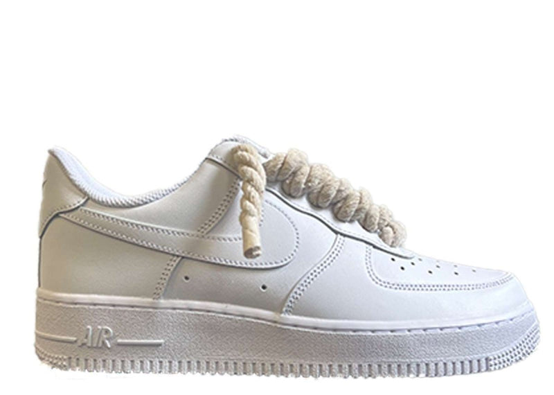 Weißer Nike Air Force 1 Schuh mit cremeweißen, dicken Rope-Schnürsenkeln, die dem klassischen Design des Schuhs einen auffälligen und modernen Akzent verleihen. Der Schuh hat eine matte Oberfläche und eine robuste schwarze Sohle, die für einen markanten Look sorgt.