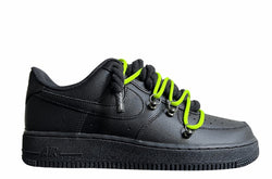 Schwarzer Nike Air Force 1 Sneaker mit dicken schwarzen Rope-Schnürsenkeln, kombiniert mit neonfarbenden Akzent-Schnüren. Der Schuh hat eine matte schwarze Oberfläche, Metallösen und eine robuste Sohle, die dem Design einen modernen und markanten Look verleiht.