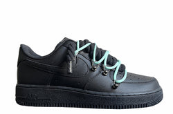 Schwarzer Nike Air Force 1 Sneaker mit dicken schwarzen Rope-Schnürsenkeln, kombiniert mit türkisen Akzent-Schnüren. Der Schuh hat eine matte schwarze Oberfläche, Metallösen und eine robuste Sohle, die dem Design einen modernen und markanten Look verleiht.